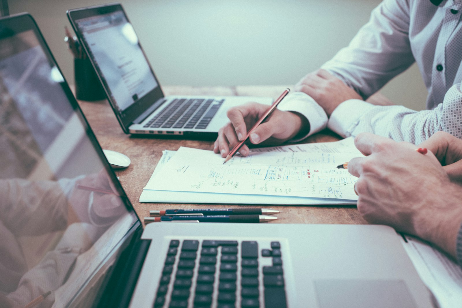 Two advisors working through system diagrams together at a desk